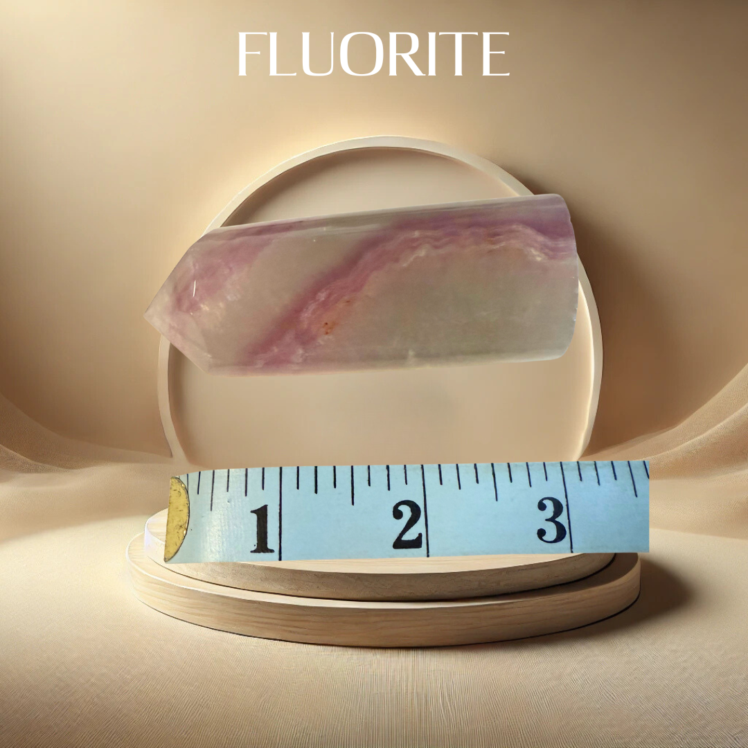 Fluorite crystal on a beige plate with a measuring tape for scale, against a beige background.