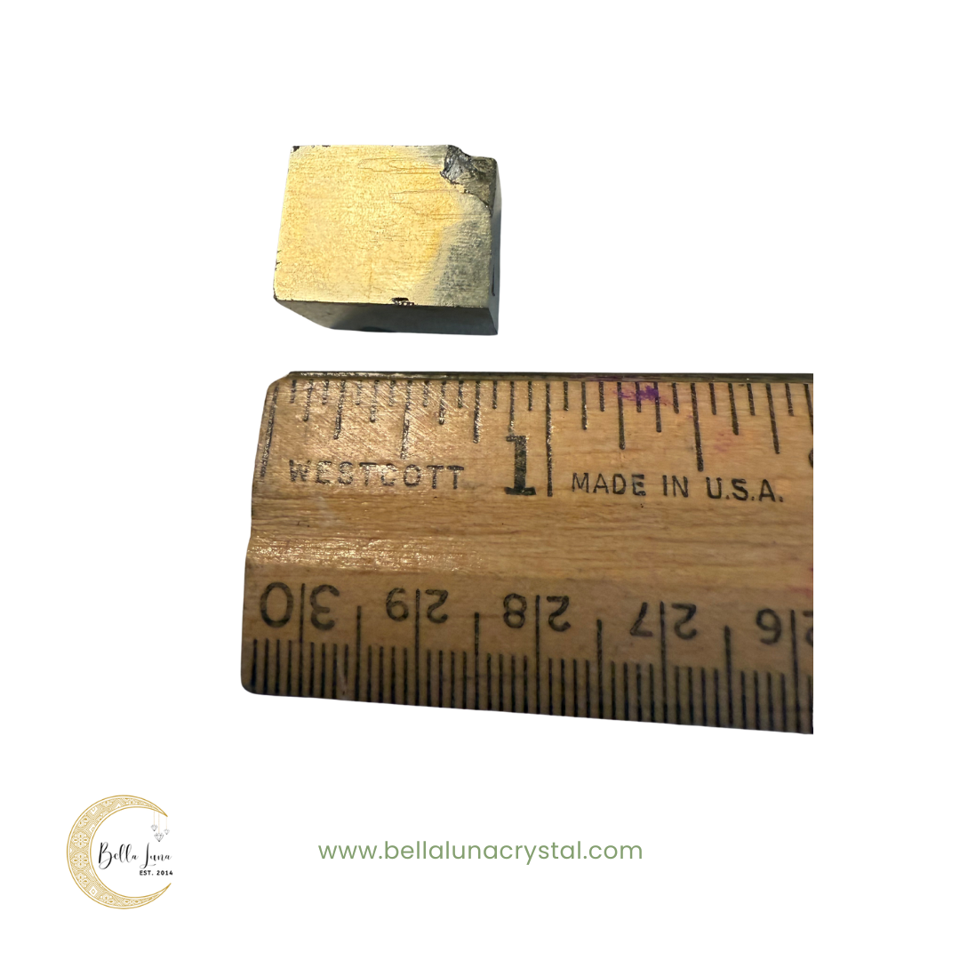 pyrite cube with a ruler for scale on a white background, featuring 'Bella Luna Crystal' branding.