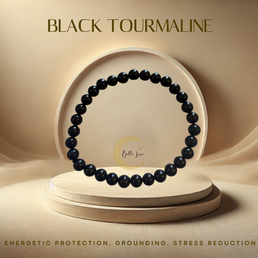A black tourmaline bracelet with 8mm beads, displayed on a wooden stand with a reflective background, with the brand name 'Bella Luna' visible.