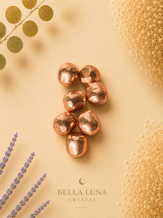 Six metallic copper nuggets arranged in a small cluster on a warm beige background, styled with botanical elements and the Bella Luna Crystal brand name.