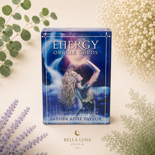 Energy Oracle Cards deck box by Bella Luna Crystal, styled on a cream background with green and white botanical sprigs. The box features a blue-toned illustration of a woman with flowing hair under a glowing moon.