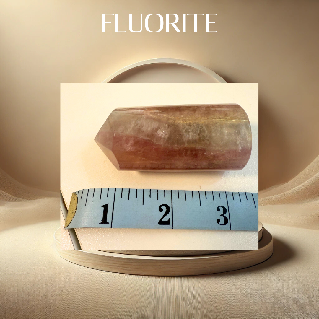 Fluorite crystal on a white card with a measuring tape for scale, against a beige background.