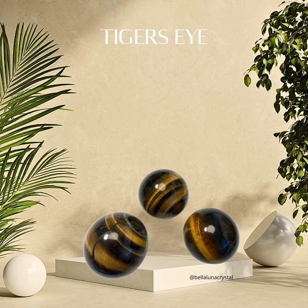 Three tiger's eye stones on a neutral background with plants on either side.
