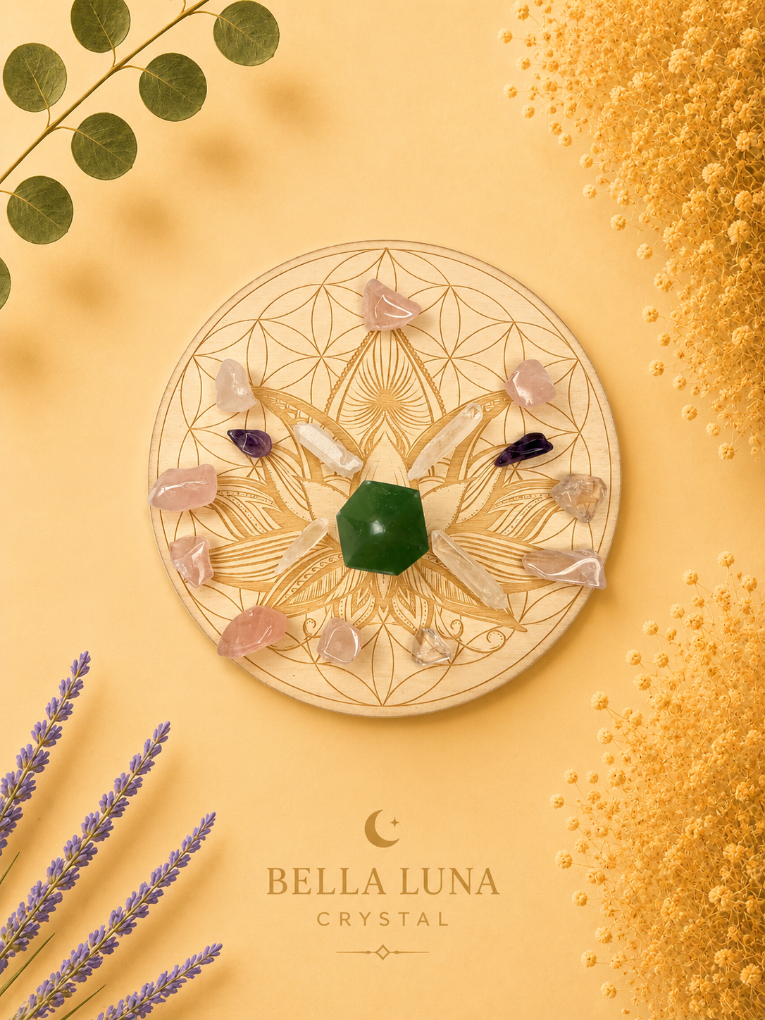 A circular crystal wheel with geometric line art, featuring a green hexagonal crystal at the center and surrounding clear and pink crystals, styled on a warm yellow background with decorative leaves, lavender, and gold powder. The brand name 'BELLA LUNA CRYSTAL' is printed at the bottom.