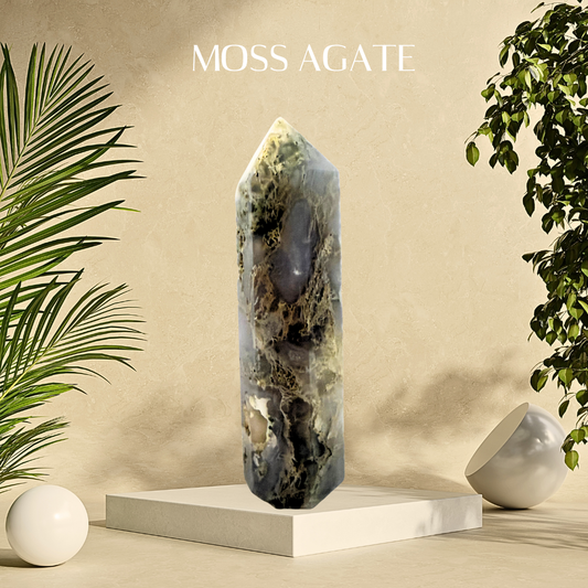 Moss agate crystal on a white pedestal with plants on a beige background