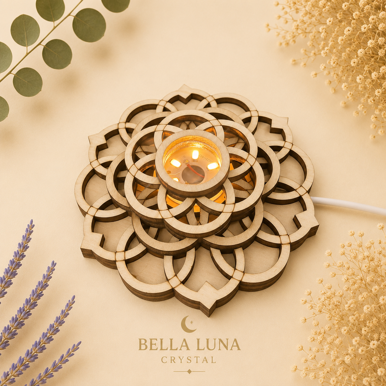 A wooden LED candle holder with a geometric mandala design, featuring a glowing warm light in the center, styled on a beige background with decorative dried flowers and greenery. The brand name 'BELLA LUNA CRYSTAL' is printed at the bottom.