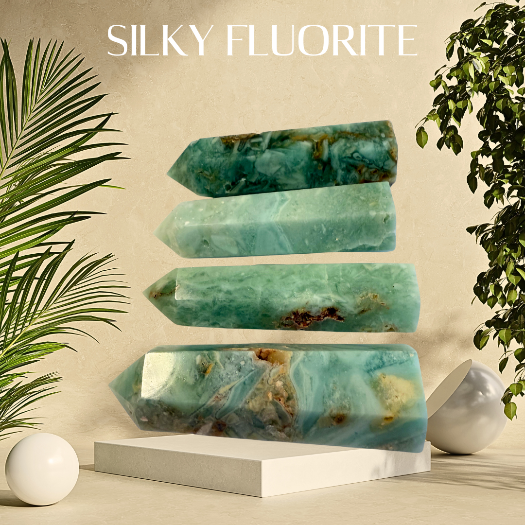 Stack of silky fluorite crystals on a neutral background with plants