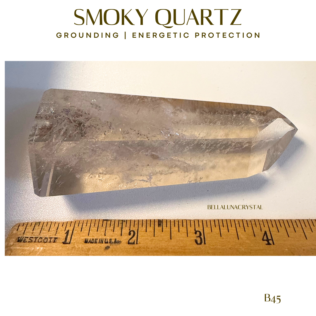 Smoky quartz crystal with a ruler for scale on a white background