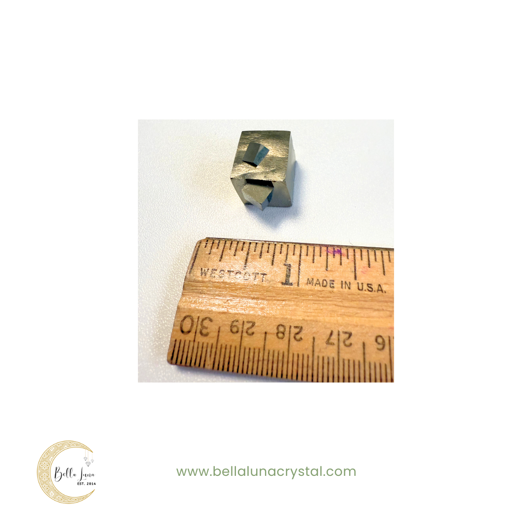 Small metal stamp next to a wooden ruler on a white background, with 'Bella Luna Crystal' branding.